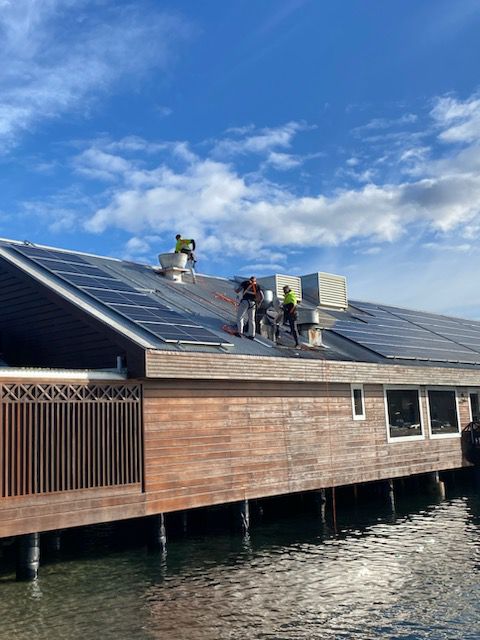 roof repairs in Sydney with trades working next to solar panels